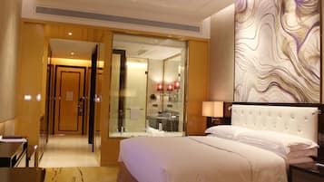 A hotel room with a large bed, a glass-enclosed bathroom, and a modern wall design.