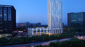 A high-rise hotel with a modern design, featuring multiple floors and a prominent entrance. - Hilton Zhengzhou (Zhengzhou)