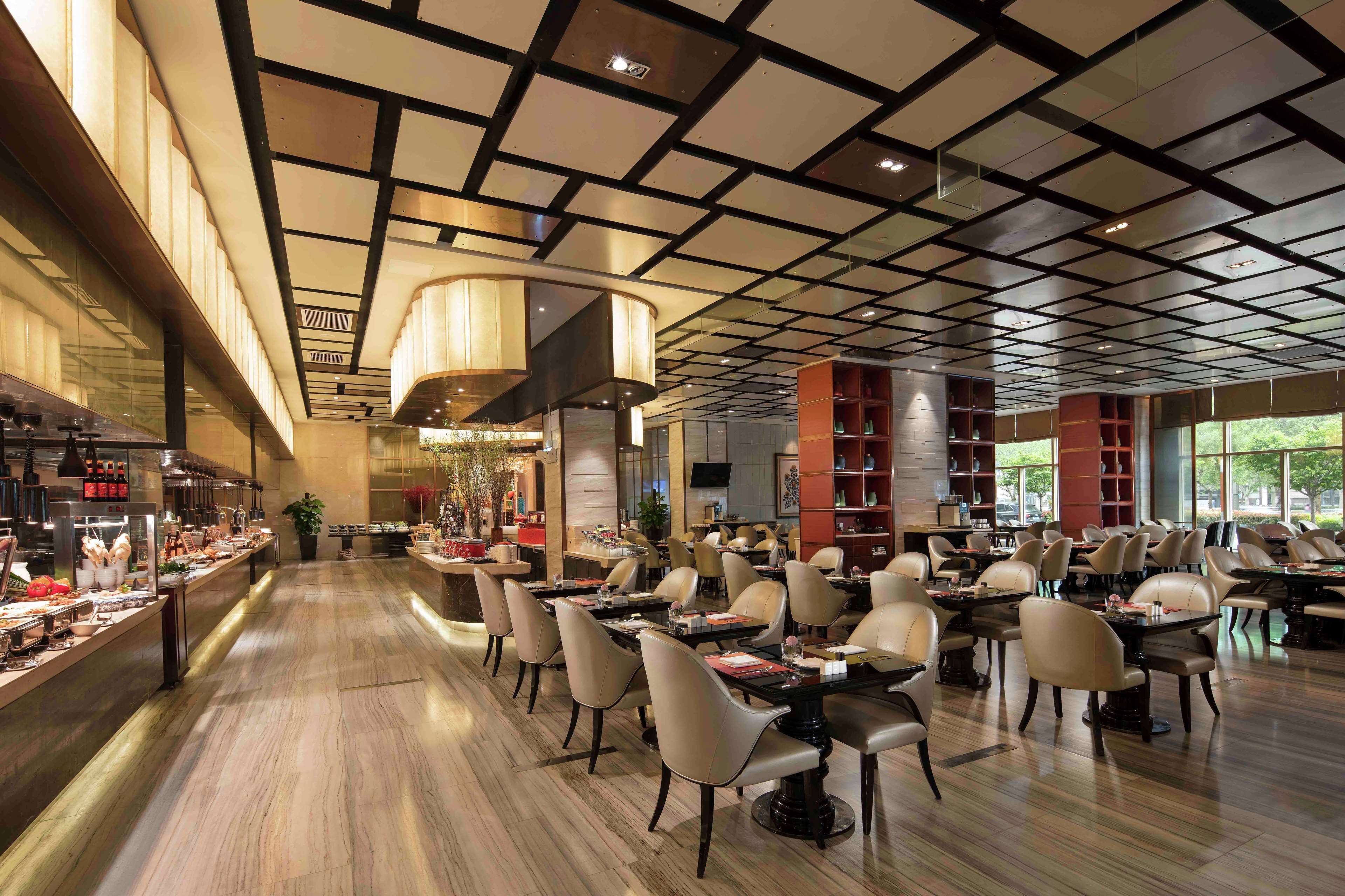 Un restaurante amplio con una barra larga, varias mesas y sillas.