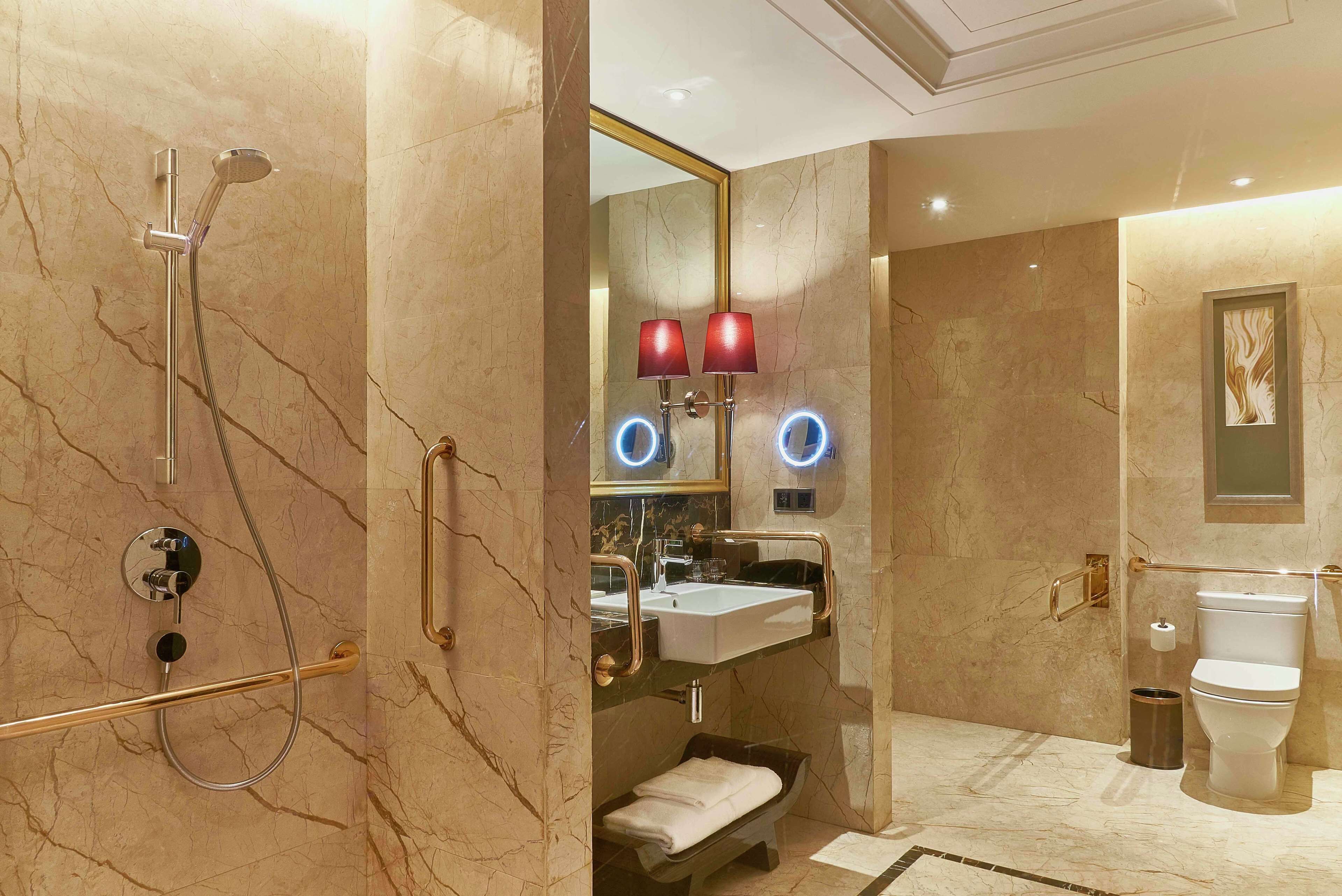 A modern bathroom with a shower, sink, and toilet.