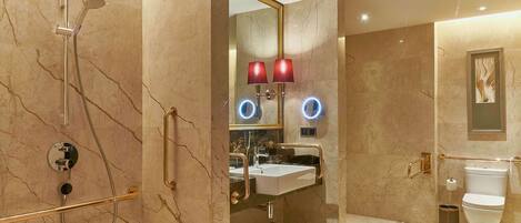 A modern bathroom with a shower, sink, and toilet.