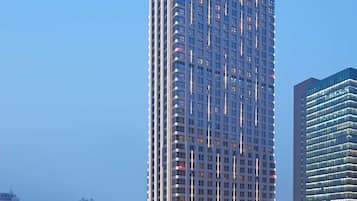 Een hoog hotelgebouw met een modern ontwerp, met een groot 'Hilton' bord bovenaan.
