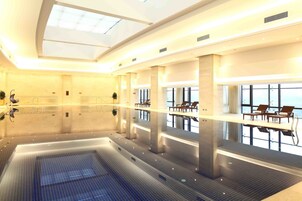 Una piscina techada, sillones reclinables de piscina