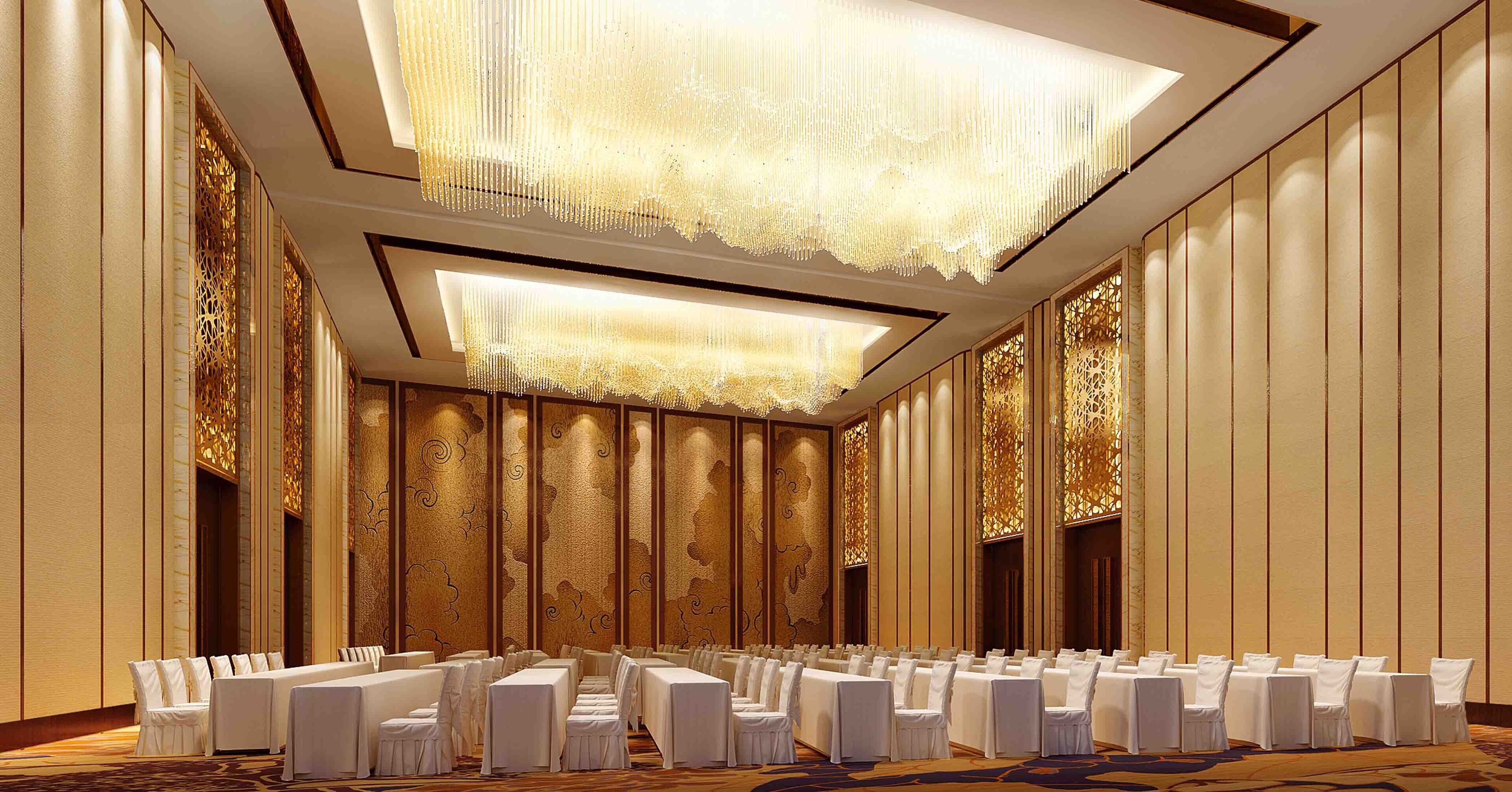 Un salón de banquetes con filas de mesas y sillas, paneles ornamentales en las paredes y una gran lámpara de candelabro.