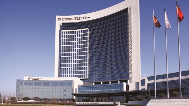 A modern hotel building with the name 'Doubletree' prominently displayed.