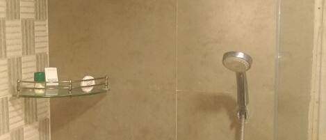 Ducha con cabezal de ducha de mano y grifo empotrado.