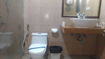 Un baño con inodoro, lavabo, espejo y ducha.