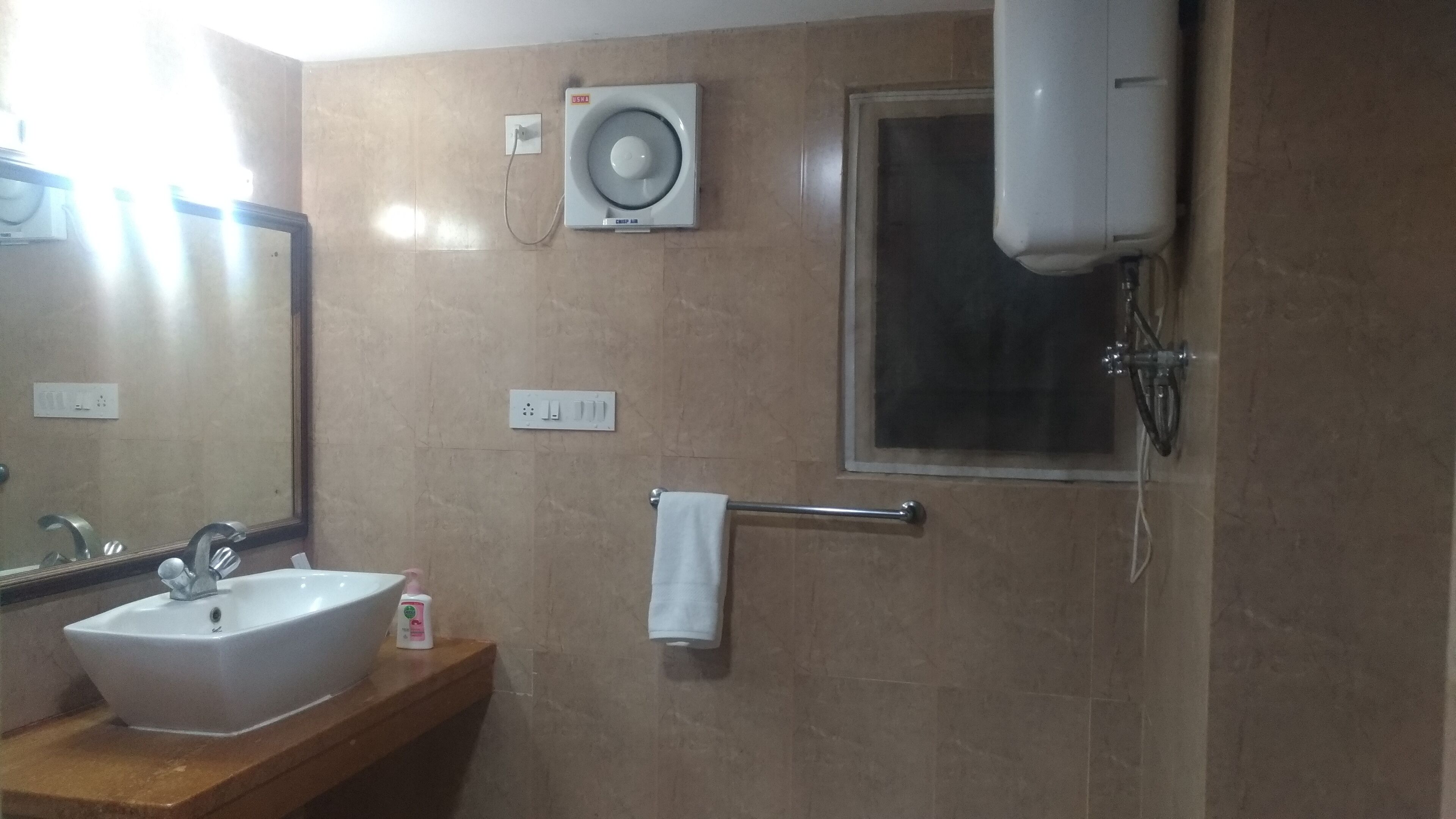 A bathroom with a sink, mirror, towel rack, and a wall-mounted air conditioner.