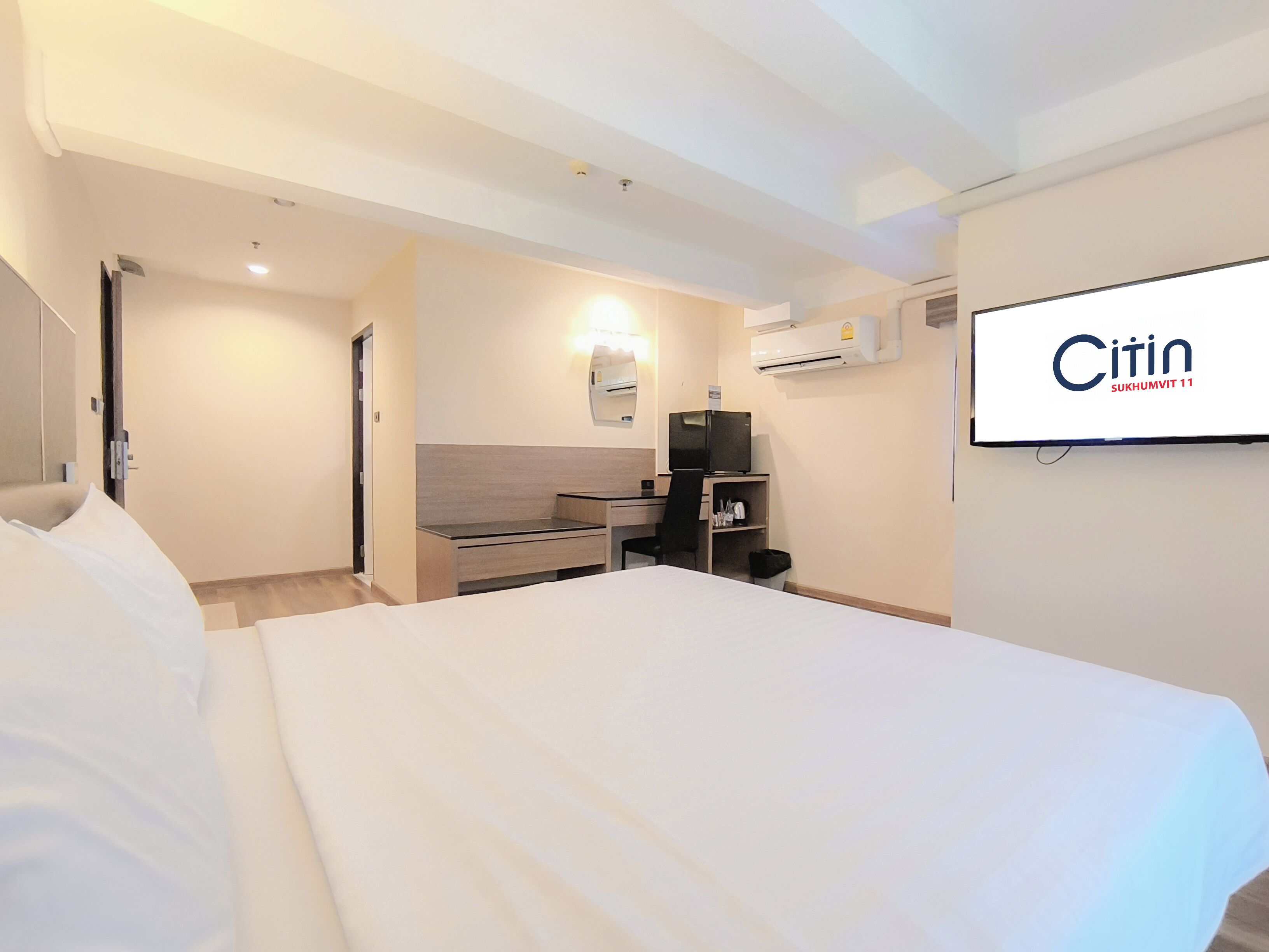 Une chambre d’hôtel équipée d’un lit, d’un bureau, d’une chaise, d’une télévision et d’un appareil de climatisation.