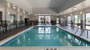 An indoor swimming pool with clear markings, a sunroof, and seating areas. - Hampton Inn & Suites Roanoke Airport (Roanoke)