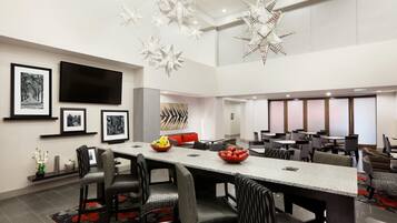 A modern dining area with a long table, chairs, and decorative star lights.