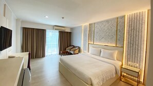 A modern hotel room with a large bed, a desk, and a seating area. - Best Beach Villa (Pattaya)