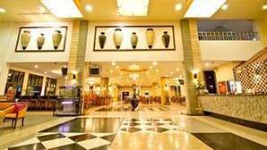 A spacious lobby with a checkered floor, a reception desk, and a series of vases on the wall. - Best Beach Villa (Pattaya)