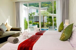 Habitación de hotel con una cama grande, un sofá y vistas a una piscina y zonas verdes.