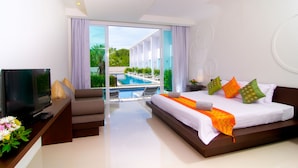 A modern hotel room with a large bed, a TV, and a view of a swimming pool. - The Palmery Resort (Karon)