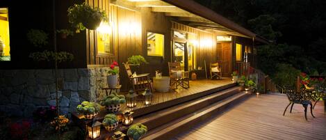 A wooden deck with outdoor seating and potted plants.