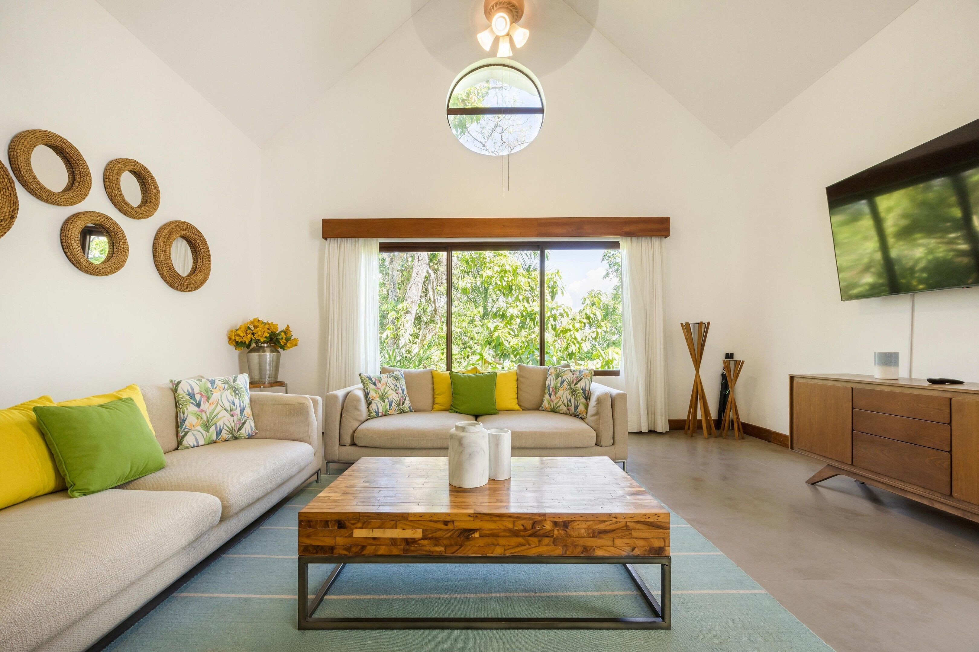 A living room with a sofa, coffee table, TV, and decorative wall elements.