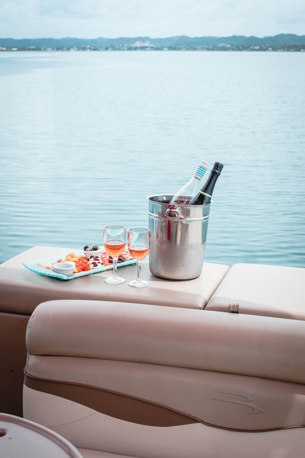 Interior de un barco con una mesa preparada para una comida, una botella de champán y copas.
