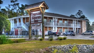 Welcome to Topsail Shores Inn, a charming two-story building with a traditional facade and a balcony on the second floor.
