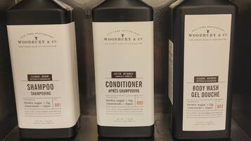 Tres botellas de productos Woodbury & Co. de Old Town Apothecary sobre una estantería.