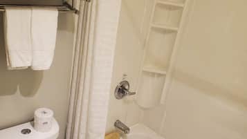 Un baño con inodoro, bañera y cortina de ducha.