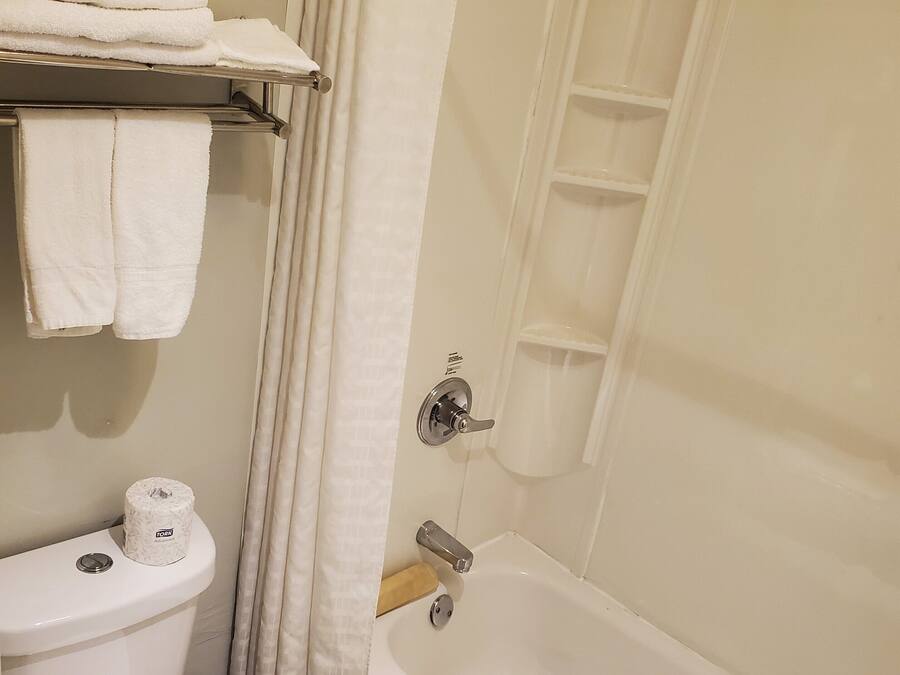 Un baño con inodoro, bañera y cortina de ducha.