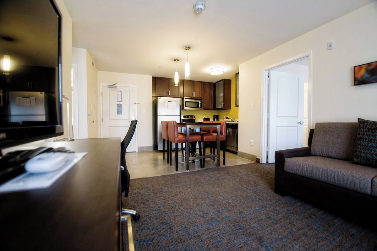 A compact living space with a kitchenette, a dining area, and a seating area.