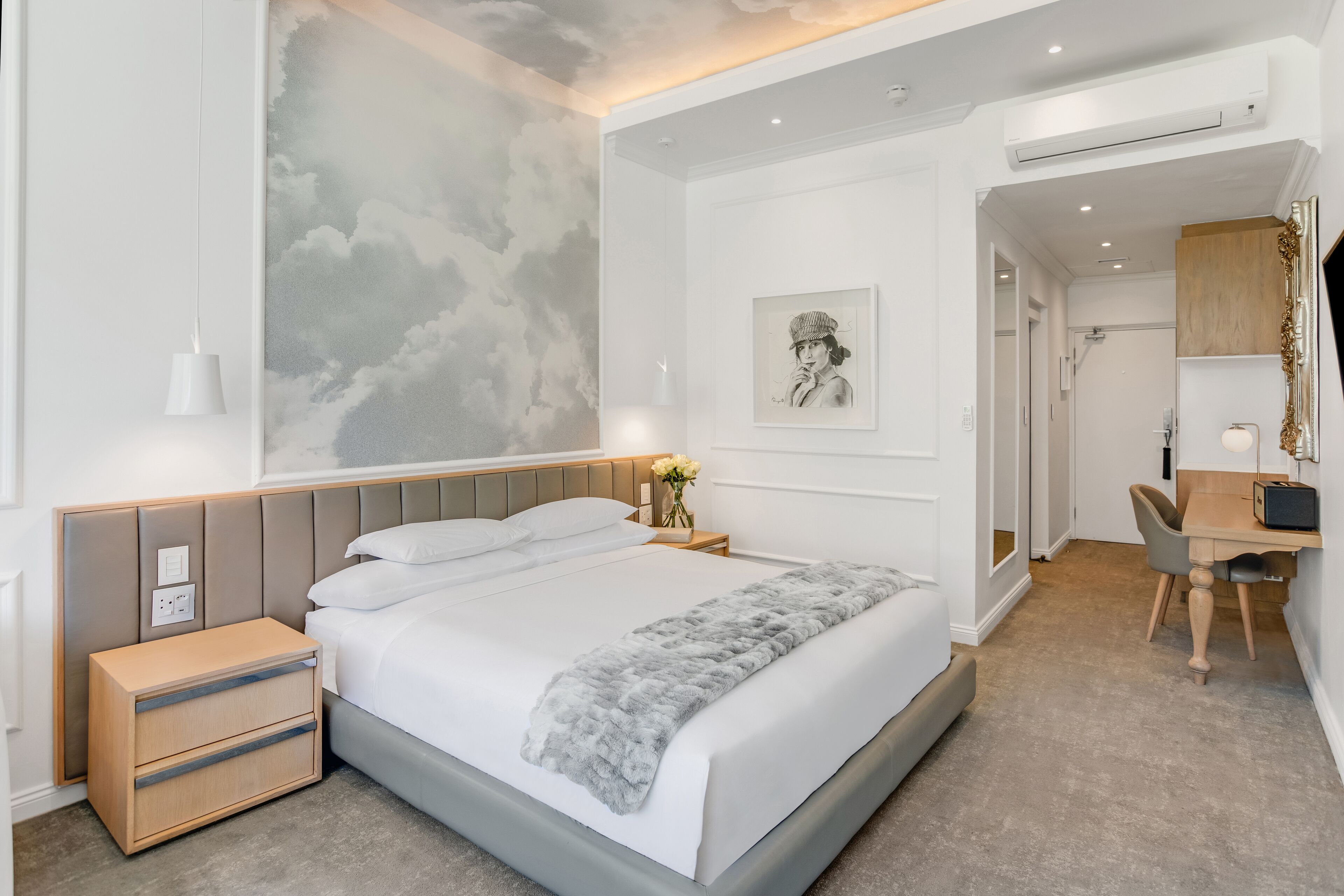 Une chambre moderne avec un grand lit, des tables de chevet, un bureau et une chaise.
