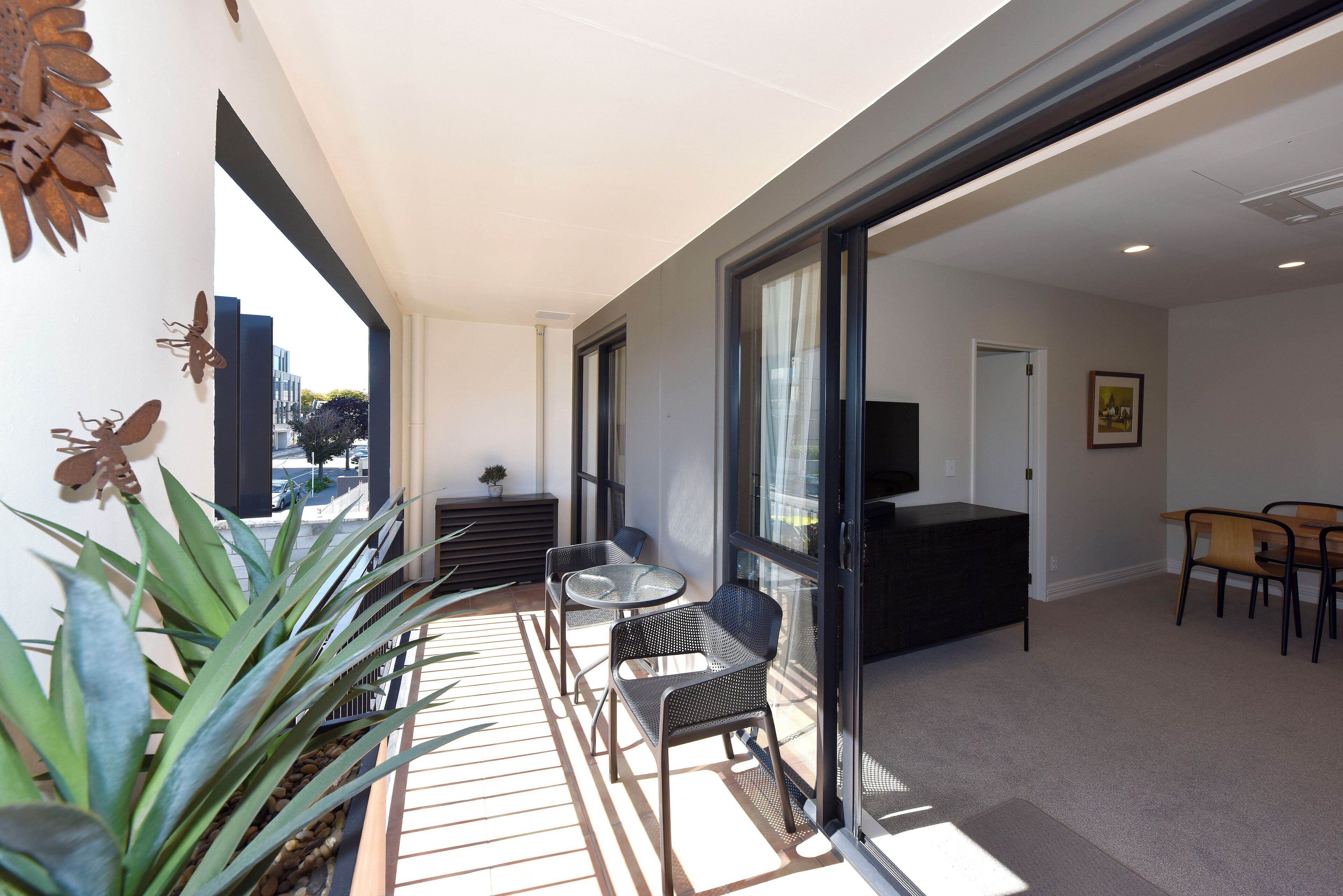 Un intérieur moderne avec un balcon, un coin salon et un espace repas.
