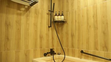 A bathroom with a wooden wall, a white toilet, a bathtub, and a towel rack.