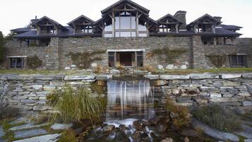 A stone building with a waterfall in front.