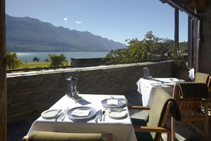 Dine al fresco with a serene lake view and distant mountains.
