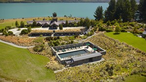A resort with a swimming pool, a large building, and a lake in the background. - Blanket Bay (Glenorchy)