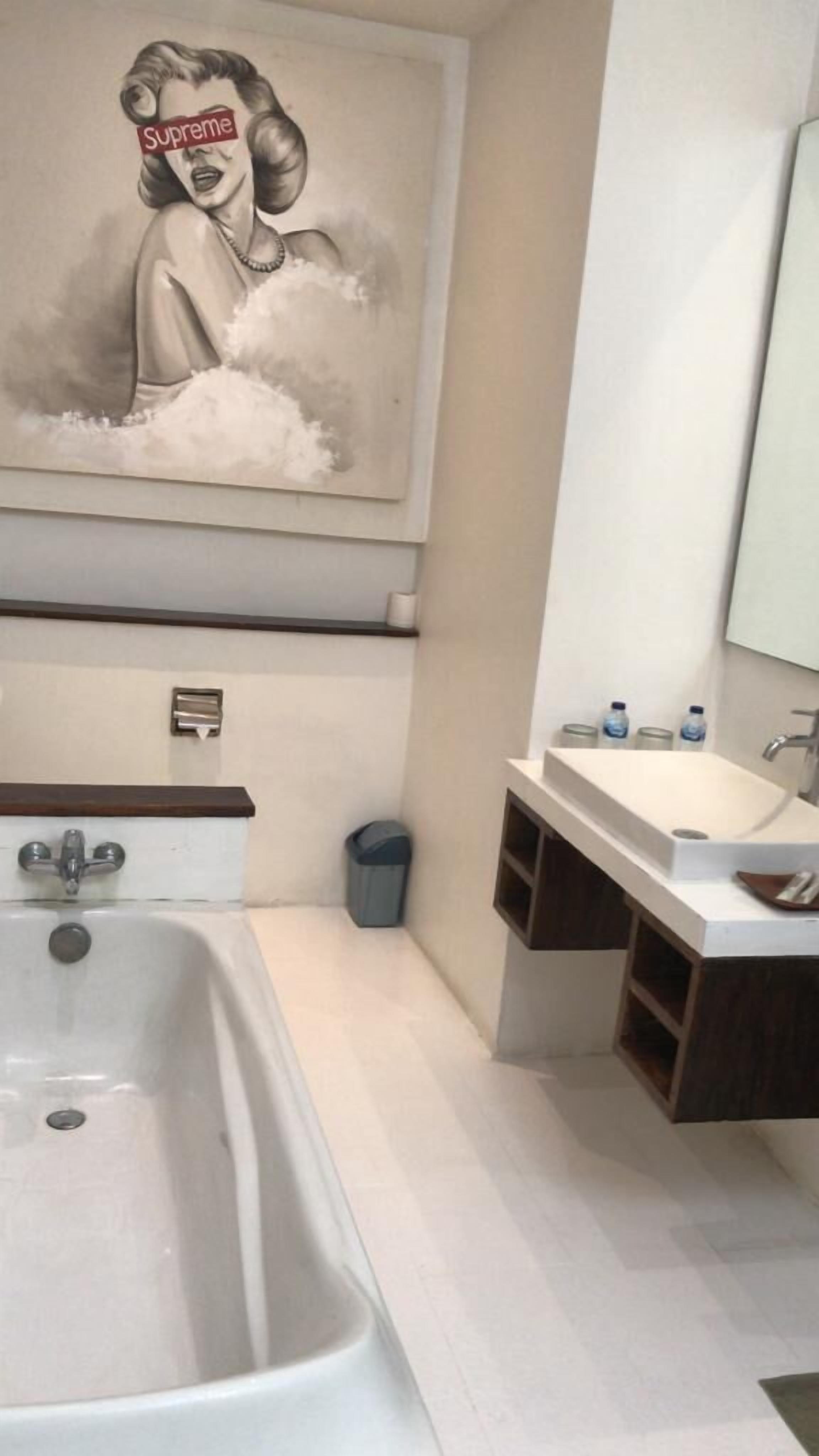 Ein modernes Badezimmer mit einer großen Badewanne, einem Waschbecken inklusive Spiegel und einem Handtuchhalter.