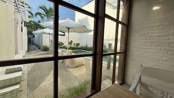 Een buitenzwembad, ligstoelen bij het zwembad