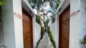 A narrow hallway with two doors labeled 102 and 101, flanked by white walls and wooden doors. - La Belle Villa (Seminyak)