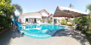Una piscina al aire libre, sombrillas, tumbonas