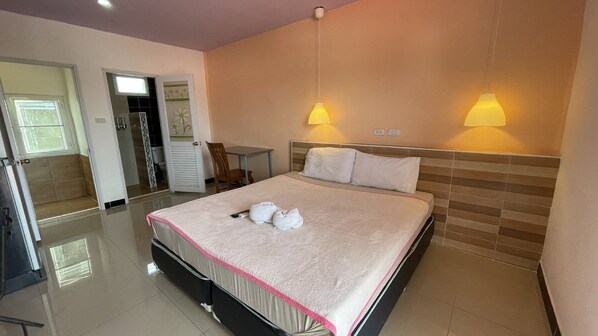 A hotel room with a bed, bedside lamps, a desk, and a chair.