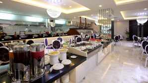 A buffet setup with various food items and drink dispensers.