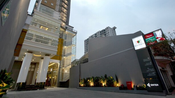 A modern building with a glass facade, a staircase leading to an entrance, and a sign indicating a restaurant and fitness center.