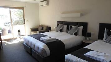 Una habitación de hotel con dos camas, un sofá, una mesita y una silla.