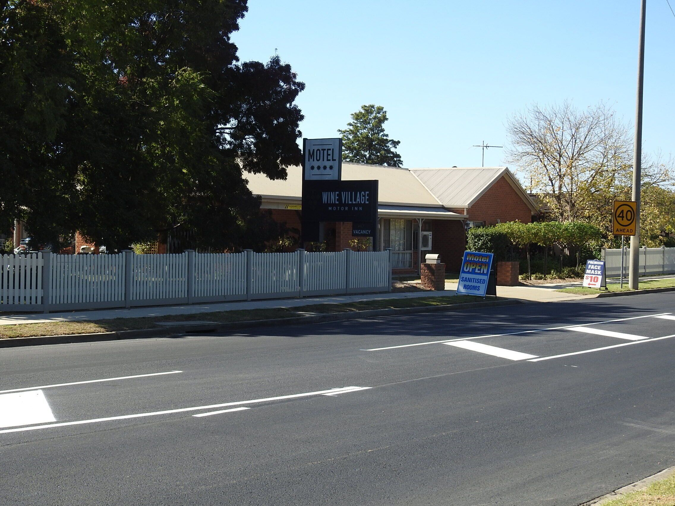 A motel named Wine Village Motel Inn with a sign indicating a vacancy.