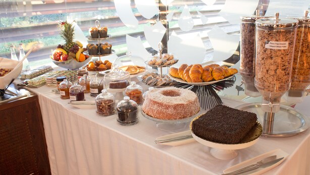 A buffet table with various food items and condiments. - Hotel Portas de Santa Rita (Valongo)