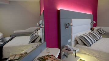 Ein Hotelzimmer mit zwei Betten, einem Nachttisch mit Lampe und einem Spiegel.