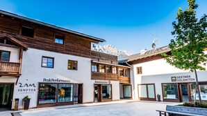 A hotel with a modern facade, large windows, and a view of mountains in the background. - Zin Senfter Residence (San Candido)