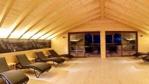 A wooden-roofed room with multiple lounge chairs arranged in rows. - Zin Senfter Residence (San Candido)