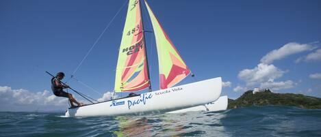 A sailboat named 'Pacific' with a person on board, sailing on the water.