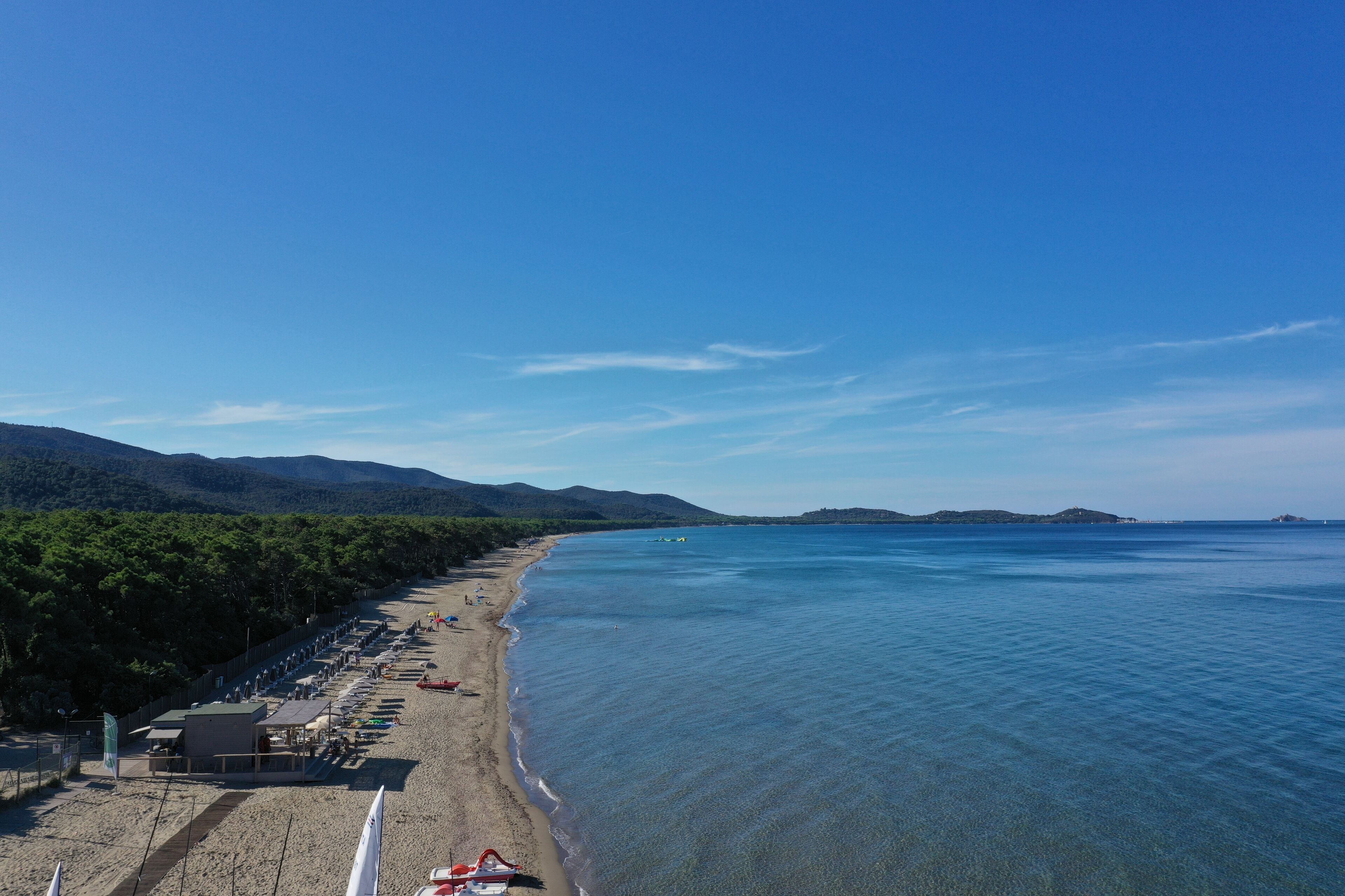 Privatstrand, Liegestühle, Sonnenschirme, Windsurfen