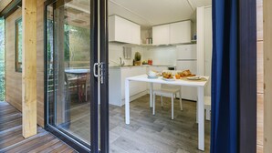 Cozinha moderna com armários brancos, uma mesa de jantar e um espaço para refeições rápidas.