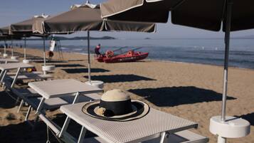Privatstrand, Liegestühle, Sonnenschirme, Windsurfen